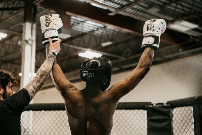 Fighter having their hand raised after a training bout in the cage