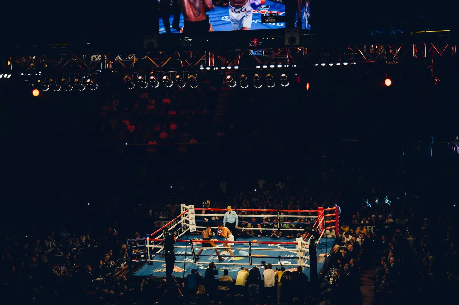 Boxing match in a packed arena, seen from the upper stands