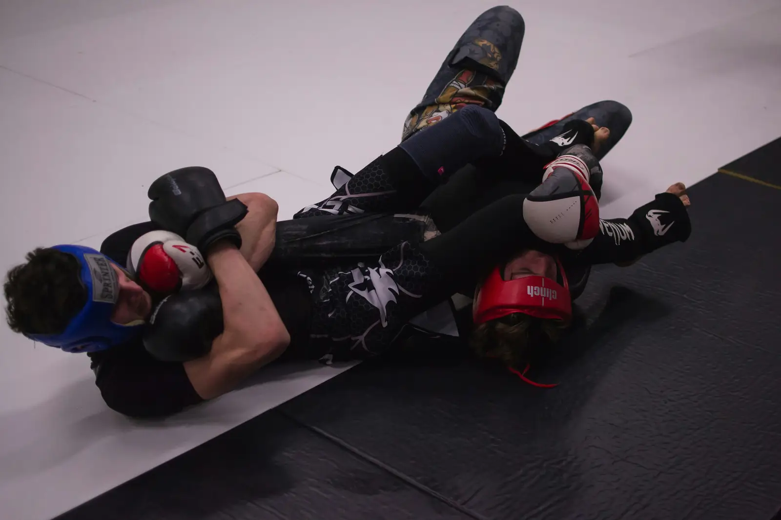 Two fighters grappling on the mat