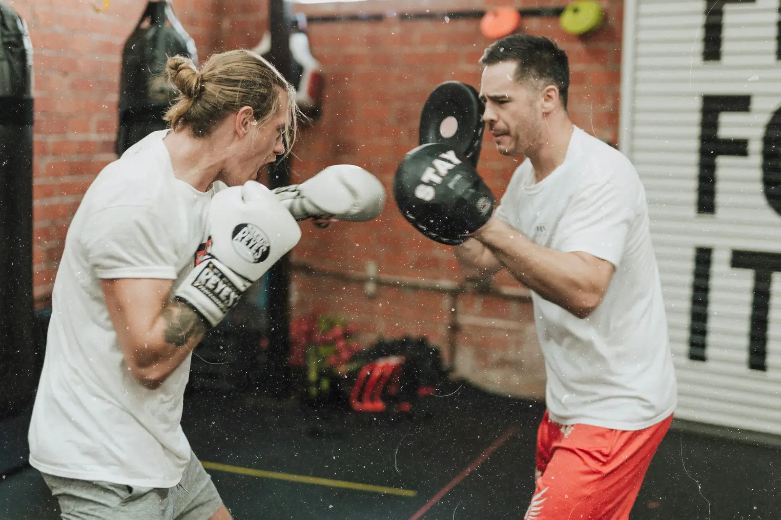 Boxer hitting pads in a gym